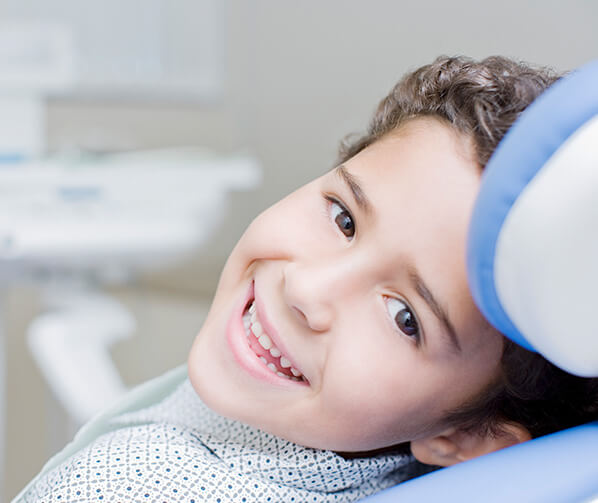 smiling boy sitting in a dental chair